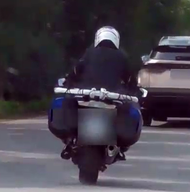 Surveillance still of the subject riding a motorcycle