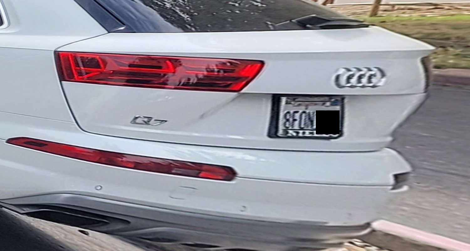 Rear of a white SUV photographed at an angle — enhanced