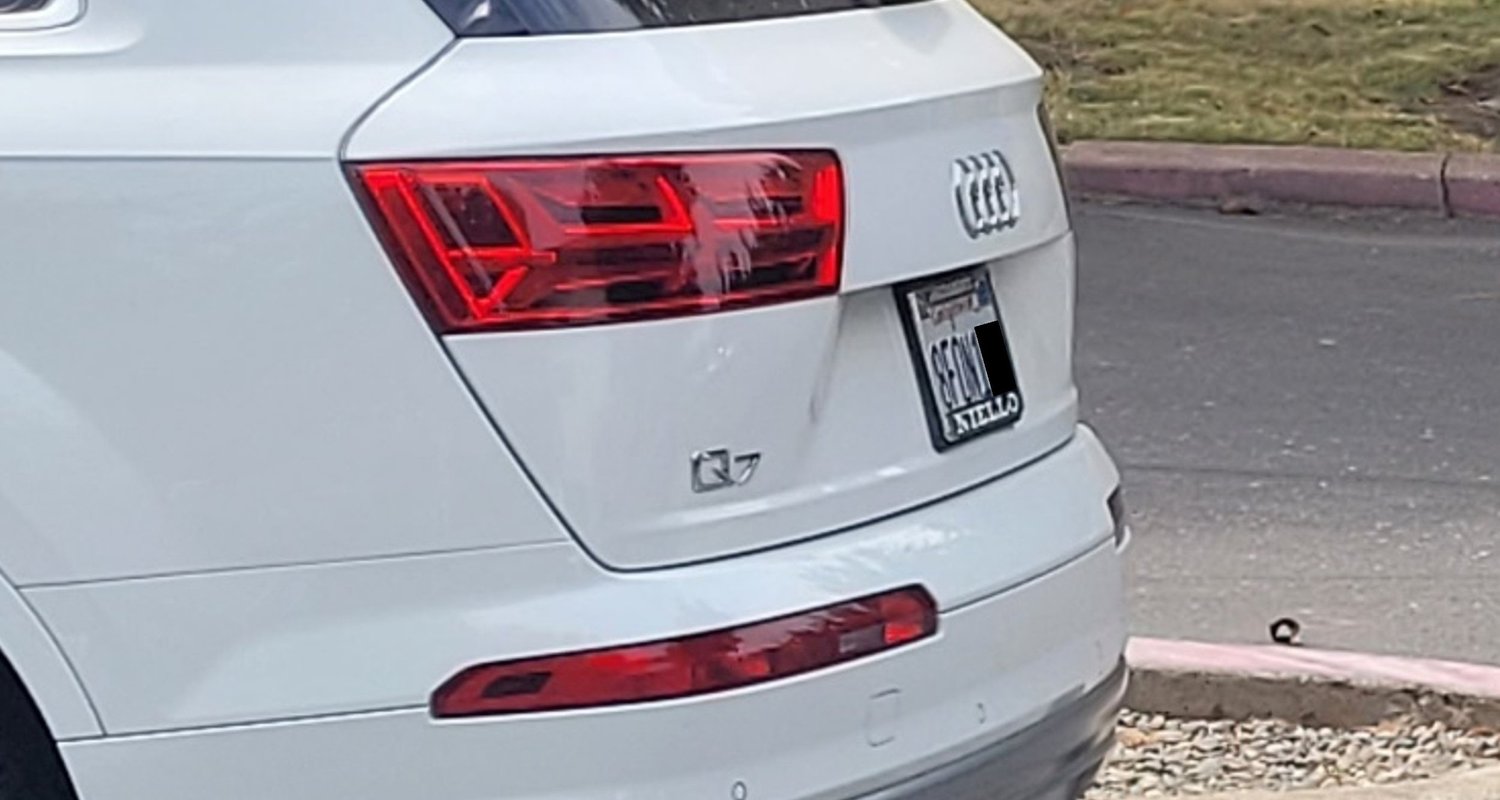 Rear of a white SUV photographed at an angle — original